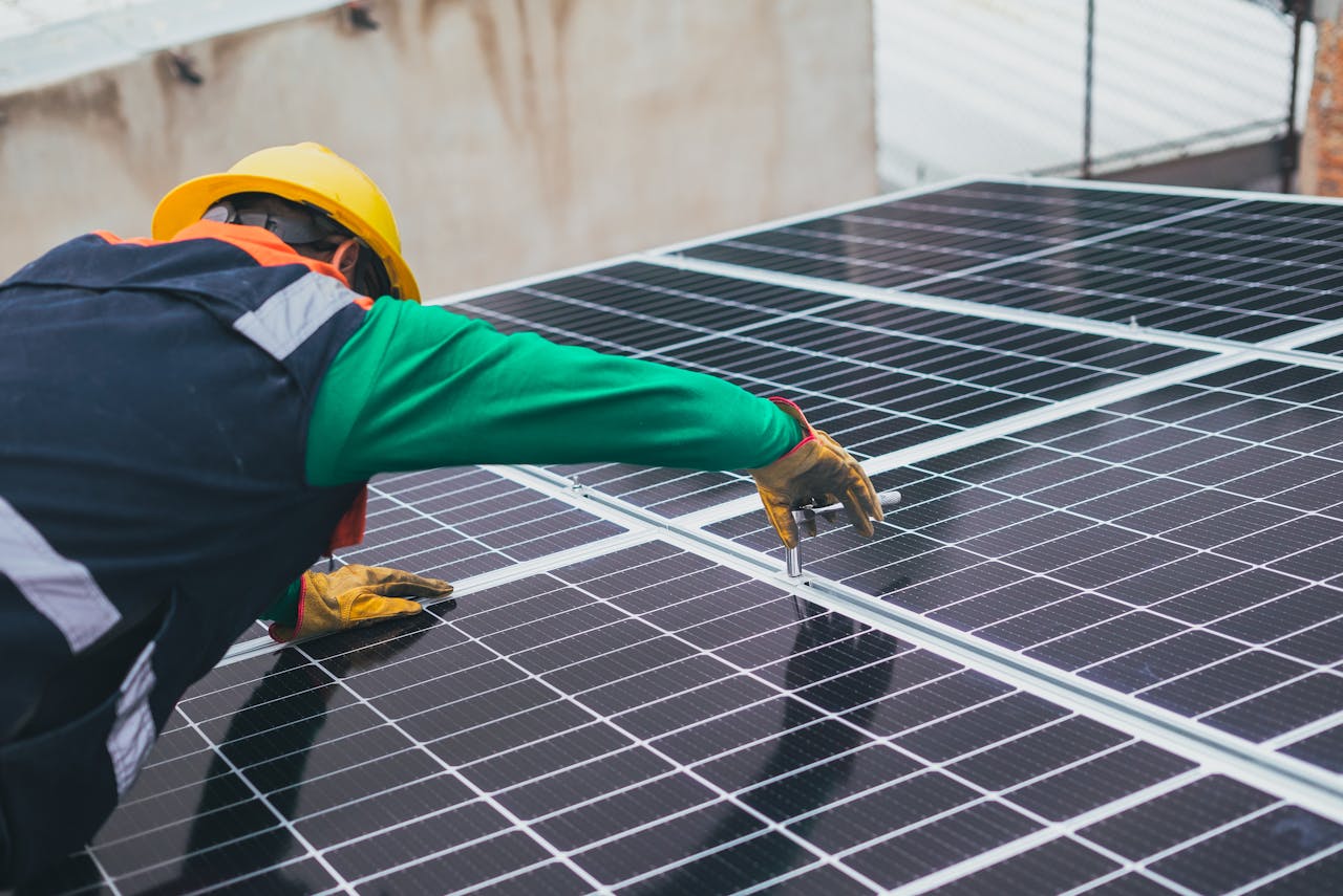 gallery-02 Technician installing solar panels on a rooftop for sustainable energy solutions.