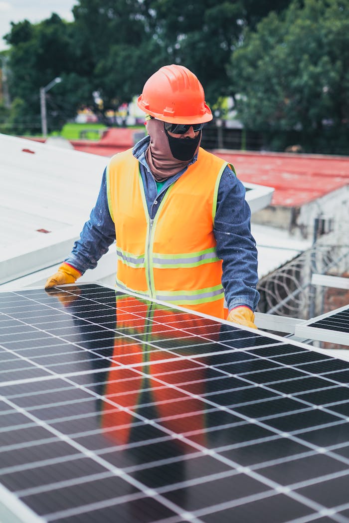gallery-03 Technician in protective gear installing solar panels on a sunny day.